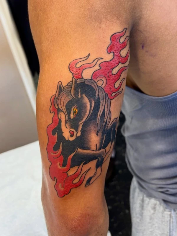 Fire horse in bold color, tattooed by Cara
