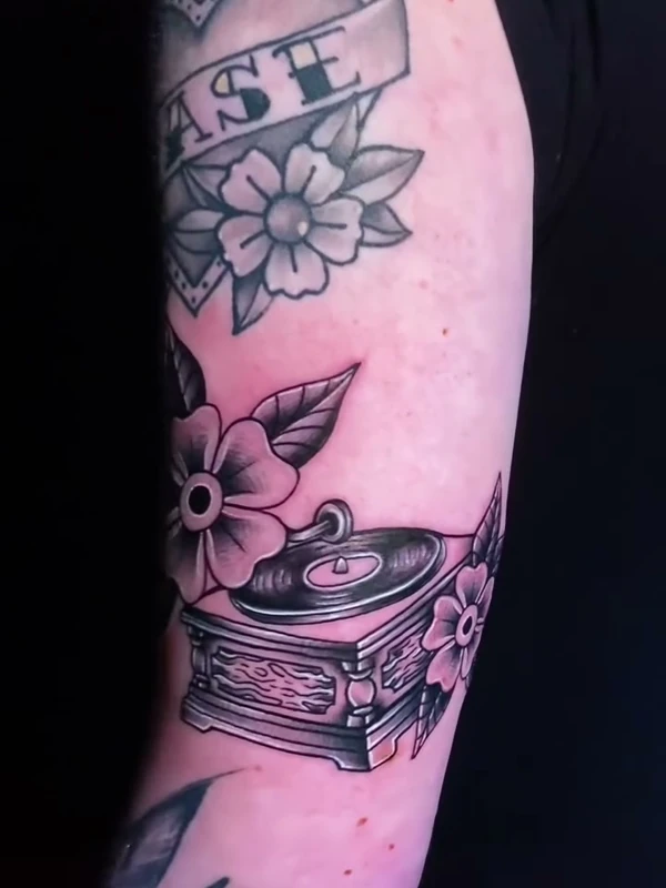Florals with a record player, tattooed by Jordan