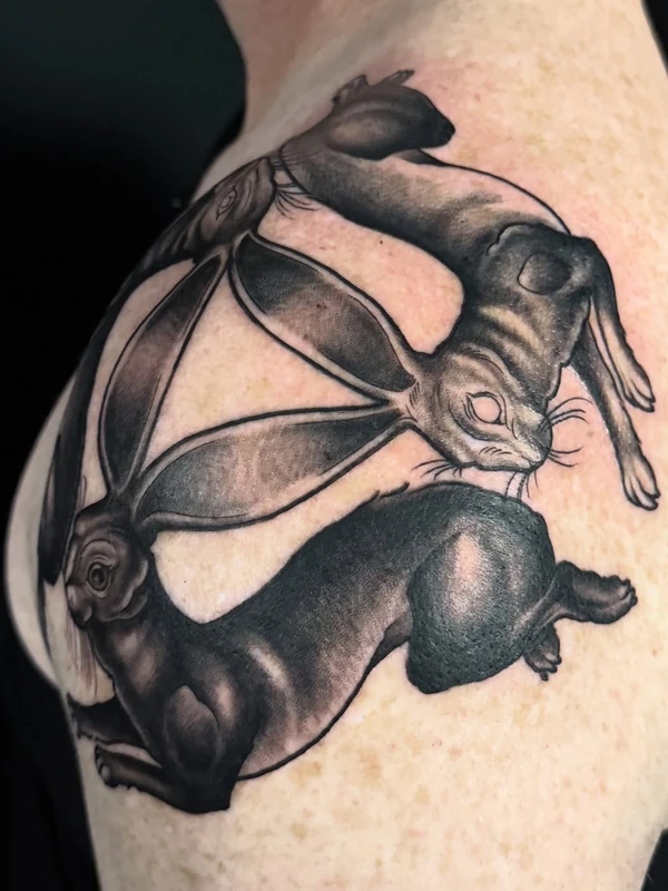 Two hares on the shoulder, tattooed by Tevin